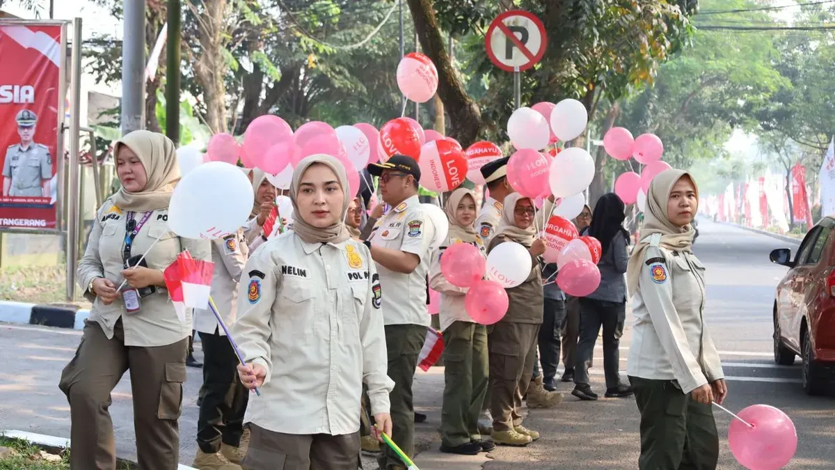 Anggota Satpol PP Kabupaten Tangerang saat membagikan bendera Merah Putih kepada pengguna jalan. (Sumber: Dok. Istimewa)