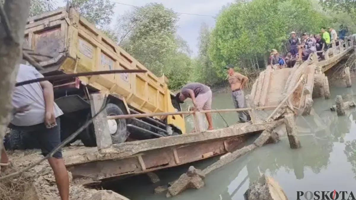 Mobil truk pengangkut pasir terperosok ke sungai saat melintasi jembatan di Kampung Citoke, Desa Mekarsari, Kecamatan Panimbang, Kabupaten Pandeglang. (Sumber: Pos Kota/ Samsul Fatoni)