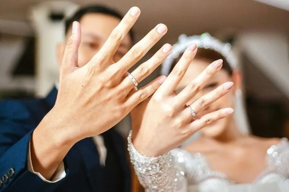 Pasangan pengantin merayakan pernikahan dengan memperlihatkan cincin pernikahan. (Sumber: Pinterest)