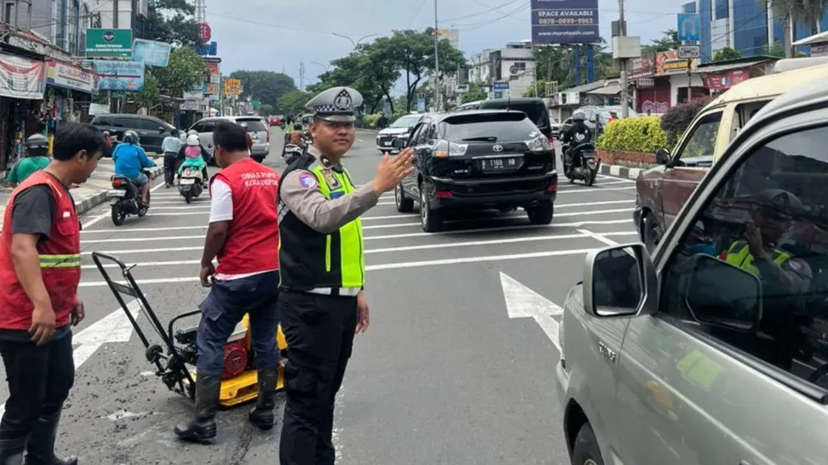 Petugas Polres Metro Depok mengawal perbaikan jalan rusak di wilayah Pancoran Mas, Kota Depok, Senin, 2 Februari 2026. (Sumber: Dok. Polres Metro Depok)
