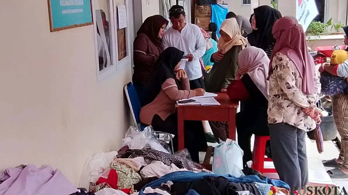 Warga terdampak membawa bantuan berupa pakaian yang disediakan di Kantor Desa Pasirlangu, Bandung Barat, Senin 2 Februari 2026. (Sumber: Poskota/Gatot Poedji Utomo)