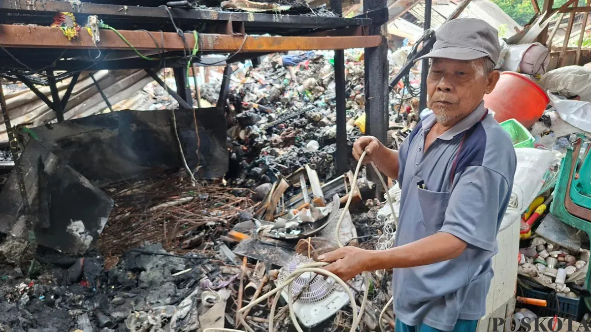 Pengepul barang bekas yang lapaknya ludes terbakar, Nur Wahid mencoba mencari sisa-sisa barang bekas yang masih dapat dijual. (Sumber: Poskota/Angga Pahlevi)