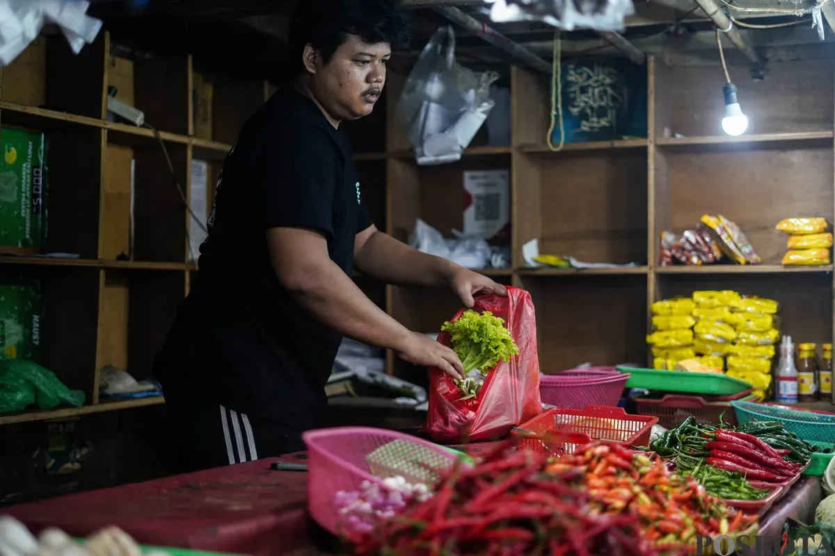 Pedagang menata sayuran dagangannya di Pasar Tebet Barat, Jakarta, Senin, 9 Februari 2026. (Sumber: Poskota/Bilal Nugraha Ginanjar)