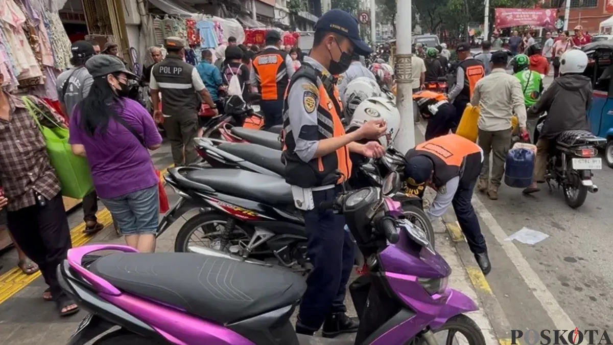 Petugas sedang merazia motor di trotoar kawasan Pecinan Glodok, Tamansari, Jakarta Barat, Rabu, 11 Februari 2026. (Sumber: Poskota/Pandi Ramedhan)