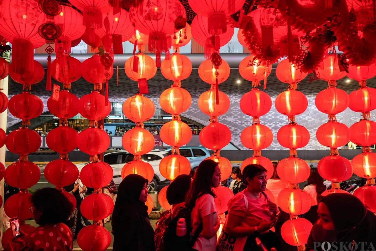 Warga berjalan melewati instalasi Festival Imlek Jakarta di kawasan Bundaran HI, Jakarta, Jumat, 13 Februari 2026. (Sumber: Poskota/Bilal Nugraha Ginanjar)