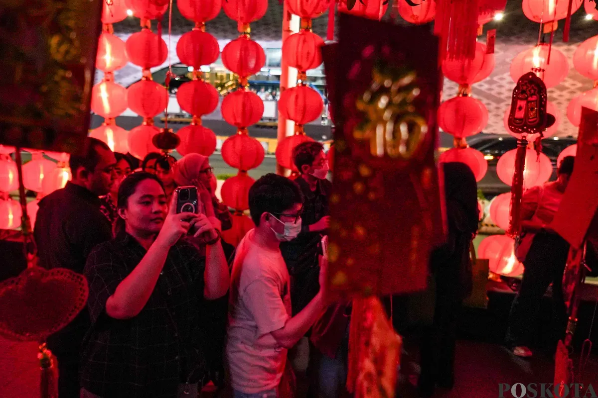 Warga berfoto dengan instalasi Festival Imlek Jakarta di kawasan Bundaran HI, Jakarta, Jumat, 13 Februari 2026. (Sumber: Poskota/Bilal Nugraha Ginanjar)