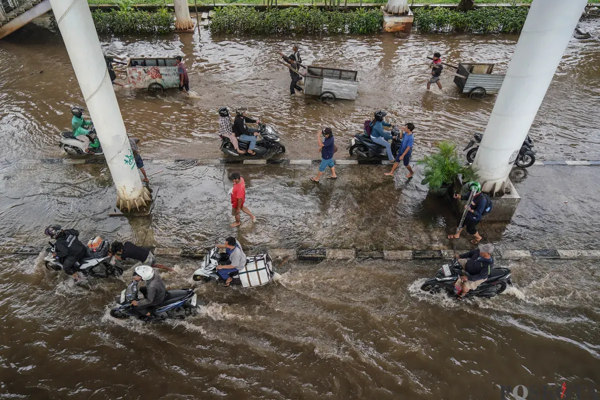 Sejumlah pengendara melintasi genangan banjir di Jalan Ciledug Raya, Jakarta Selatan, Jumat, 20 Februari 2026. (Sumber: Poskota/Bilal Nugraha Ginanjar)
