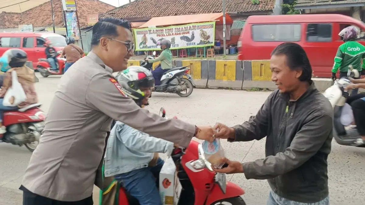 Petugas Polsek Ciruas membagikan takjil kepada pengguna jalan di depan Mako Polsek Ciruas. (Sumber: Dok. Polsek Ciruas)