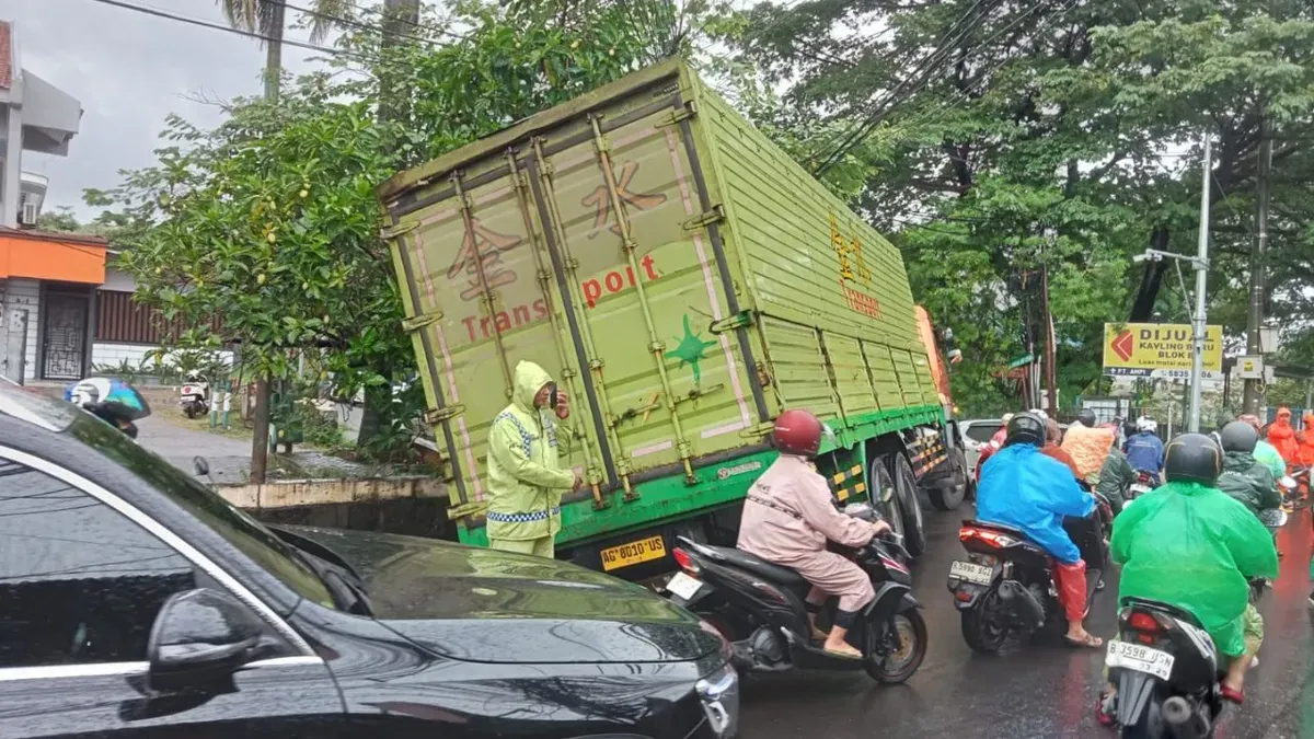 Sebuah truk terperosok ke saluran air di Jalan Puri Kembangan, Cengkareng, Jakarta Barat (Jakbar), Jumat, 20 Februari 2026. (Sumber: X/@TMCPoldaMetro)