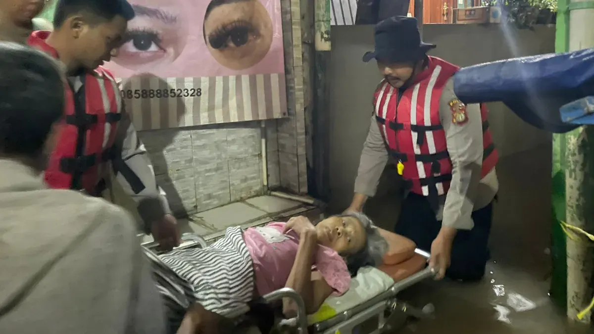 Personel Direktorat Samapta (Ditsamapta) Polda Metro Jaya mengevakuasi seorang warga lanjut usia yang sedang sakit akibat banjir di Jalan Kebon Pala, Kampung Melayu, Jakarta Timur. (Sumber: Polda Metro Jaya)