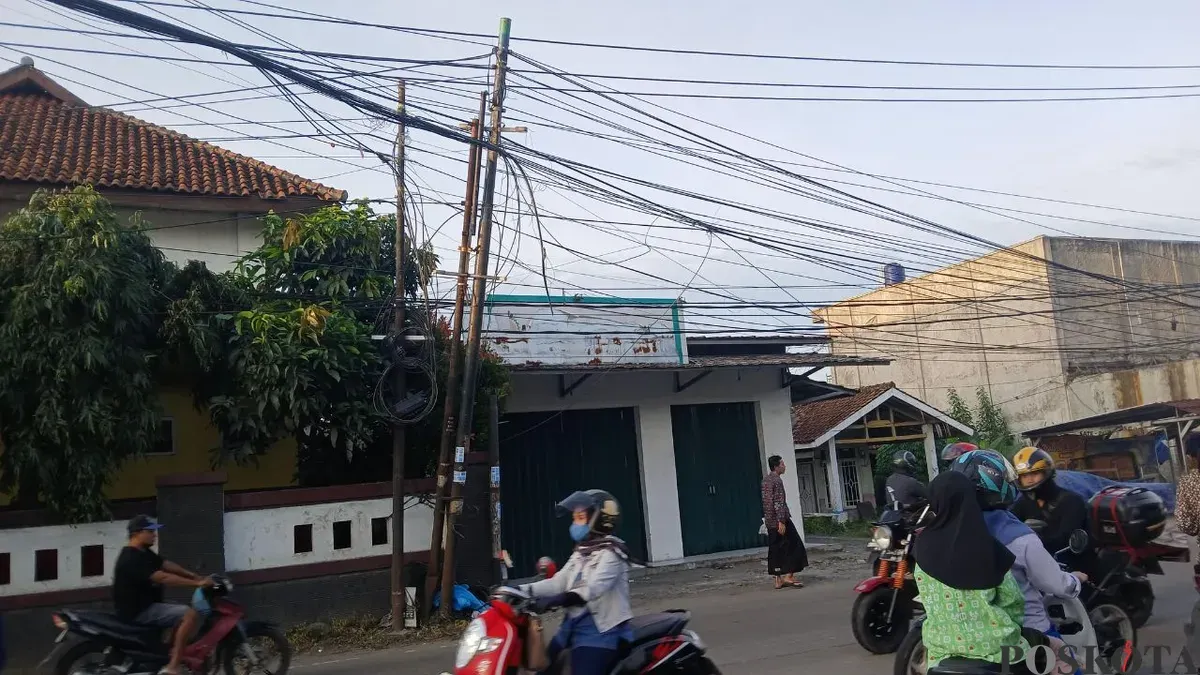 Kondisi kabel semrawut dan menjuntai di Jalan Raya Tigaraksa-Citeras tepatnya pertigaan Sekolah Dasar Negeri (SDN) III. (Sumber: Poskota/Veronica Prasetio)