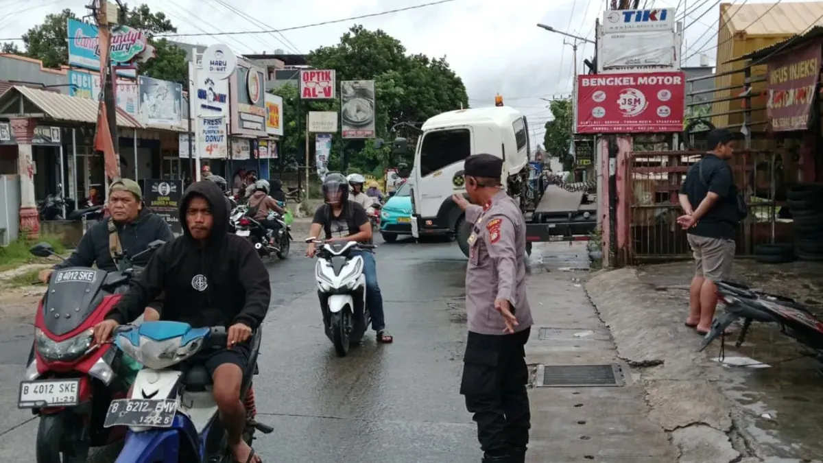 Petugas mengatur lalu lintas di lokasi truk kontainer peti kemas terperosok di Jalan Raya Limo, Kota Depok, Sabtu, 3 Januari 2026. (Sumber: Dok. Polsek Cinere)
