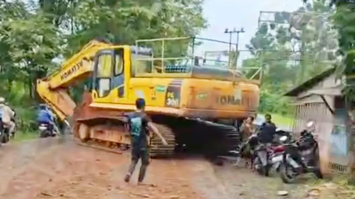 Ekskavator terlepas dari mobil trailer saat melintas di Jalan Raya Jonggol-Cariu, Kabupaten Bogor. (Sumber: istimewa)