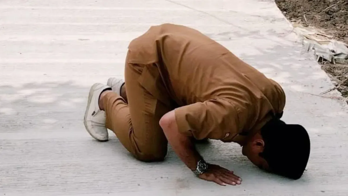 Kepala Desa Karyajaya, Kecamatan Cimarga, Lebak, Jaeni saat sujud di atas jalan yang baru dibangun. (Sumber: Istimewa)