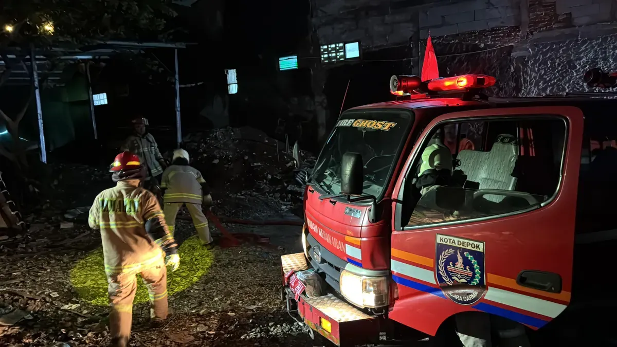 Petugas Damkar Kota Depok melakukan proses pemadaman di lokasi kebakaran rumah dan kontrakan Kecamatan Cimanggis, Depok, Selasa, 6 Januari 2026, malam. Kebakaran terjadi saat ponsel yang dicas di atas kasur. (Sumber: Istimewa)