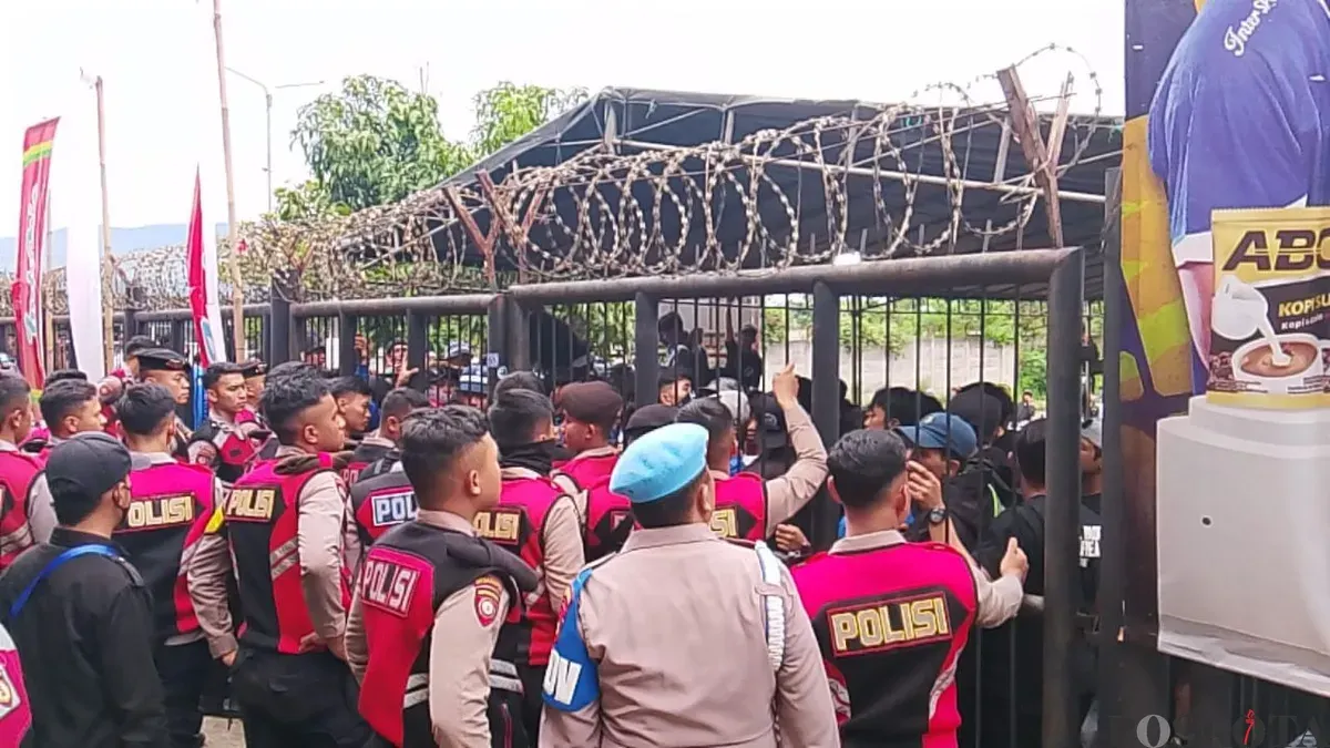 Aparat kepolisian menahan aksi bobotoh yang memaksa masuk ke dalam stadion, Minggu 11 Januari 2025. (Sumber: Poskota/Gatot Poedji Utomo)