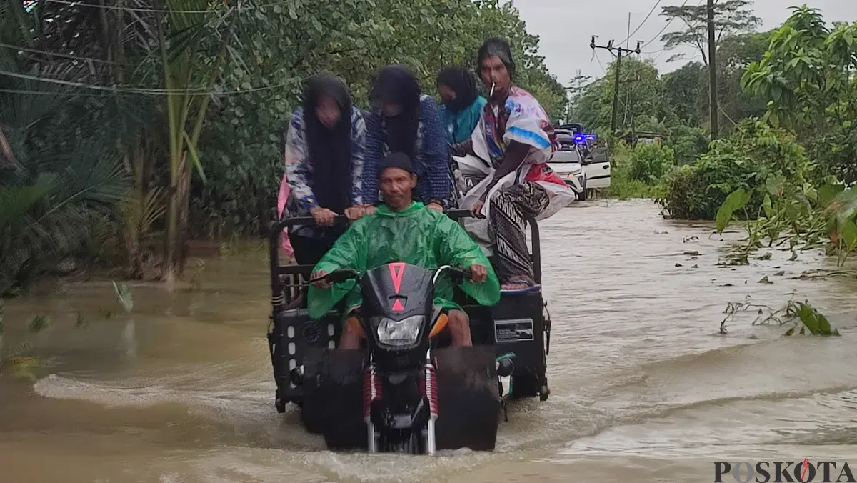 Pelaku jasa ojek tosa di Pagelaran, Pandeglang, saat mengangkut warga di tengah banjir merendam jalan raya. (Sumber: Poskota/Samsul Fatoni)