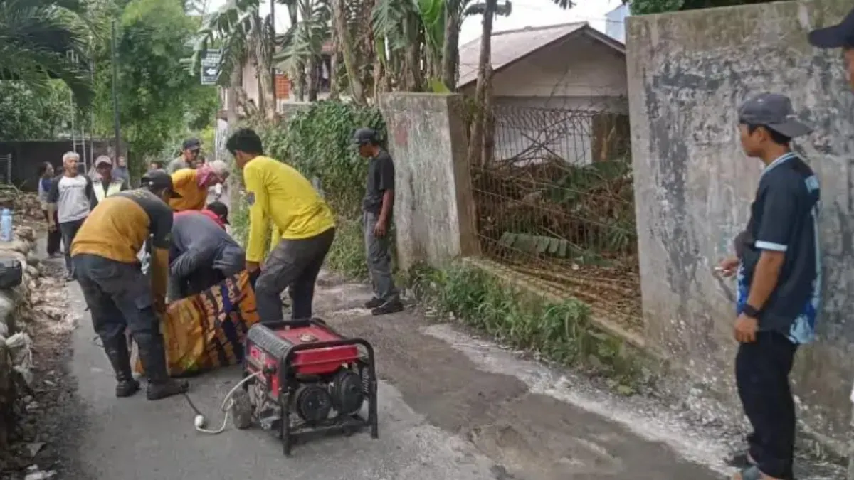 Petugas DPUPR Kota Depok memperbaiki jalan yang amblas di Jalan Manggis RT 01 RW 13, Kelurahan Rangkapan Jaya Baru, Kecamatan Pancoran Mas, Kota Depok. (Sumber: DPUPR Kota Depok)