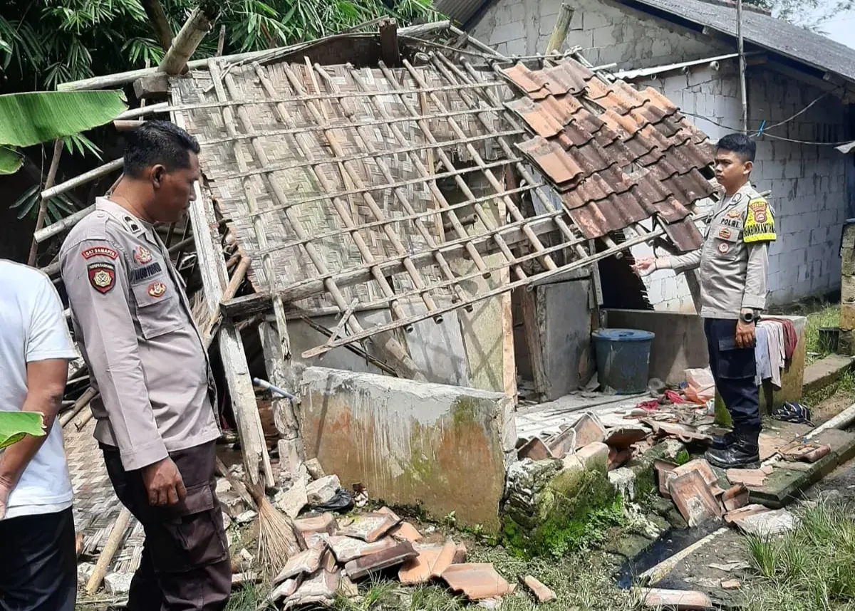 Petugas Polsek Pamarayan melakukan pengecekan terhadap kondisi rumah roboh milik Kulsum yang tidak layak huni. (Sumber: Istimewa)