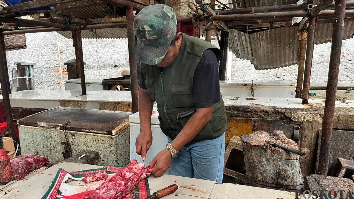 Pedagang daging sapi di Pasar Cakung, Jakarta Timur, Suryadi mencincang barang jualannya, Kamis, 22 Januari 2026. (Sumber: Poskota/M. Tegar Jihad)