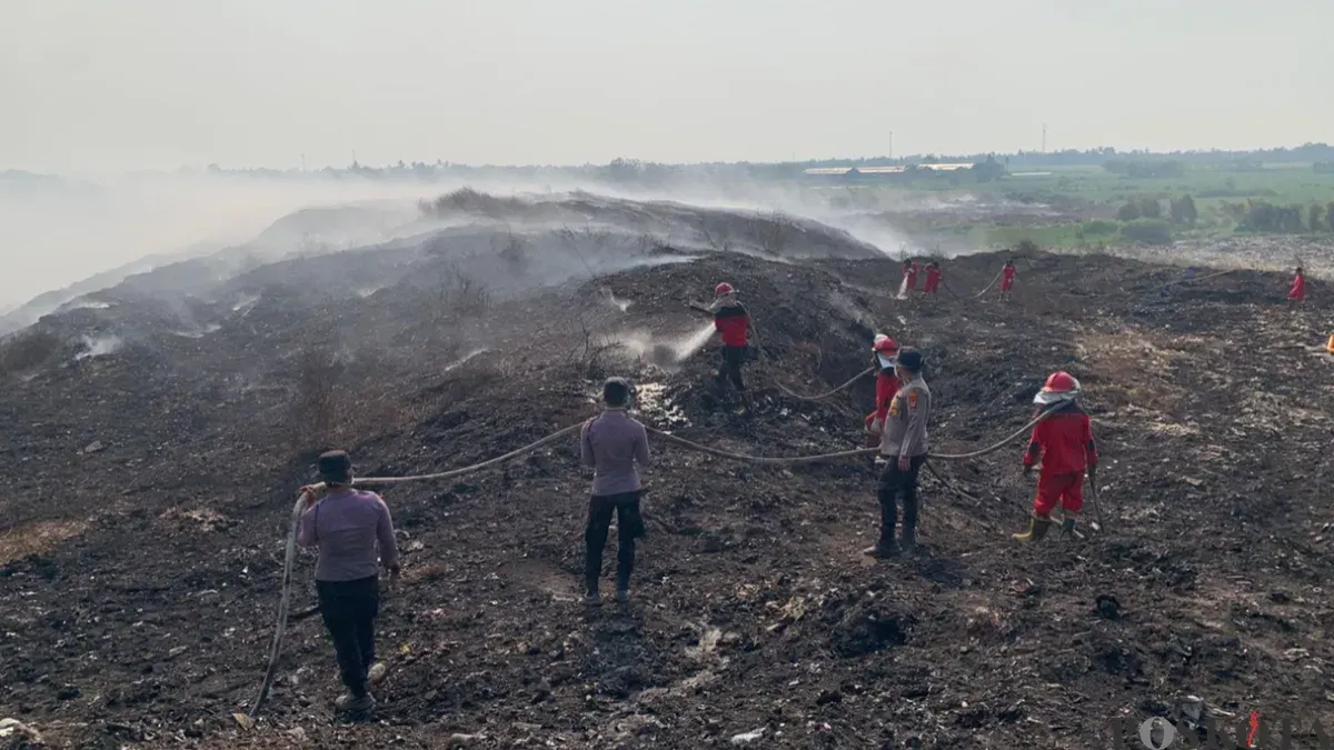 Petugas gabungan saat memadamkan api di TPA Jatiwaringin. (Sumber: Poskota/Veronica)