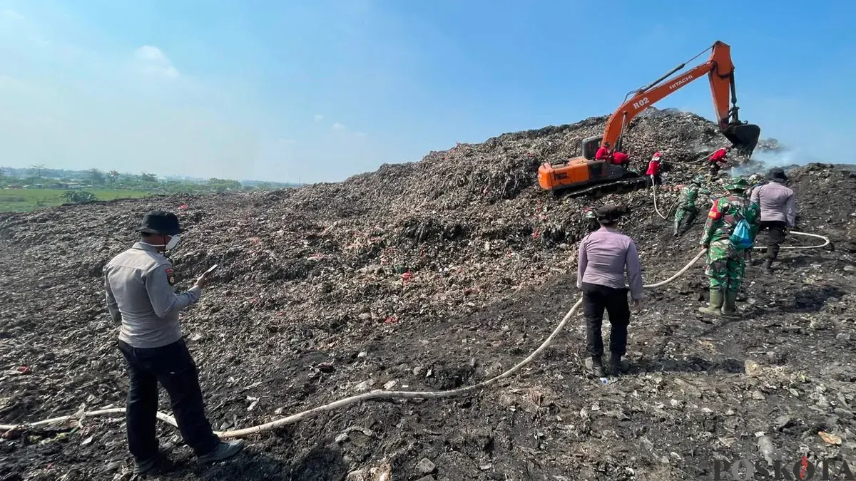 Petugas gabungan saat memadamkan kebakaran TPA Jatiwaringin Kecamatan Sukadiri, Kabupaten Tangerang. (Sumber: Poskota/Veronica Prasetio)