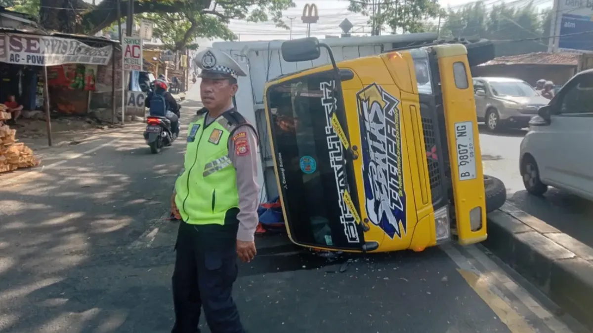 Petugas Lantas Polsek Beji melakukan pengaturan lalu lintas di Jalan Raya Bojongsari mengucari kemacetan akibat ada truk terguling, Rabu siang, 15 Juli 2026. (Sumber: Poskota/ Angga)