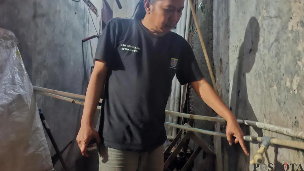 Ketua RW 15, Arif Afifullah menunjukan kran air di rumahnya saat musim kemarau serta wilayahnya yang mengalami kekeringan. ( (Sumber: Poskota/Angga)