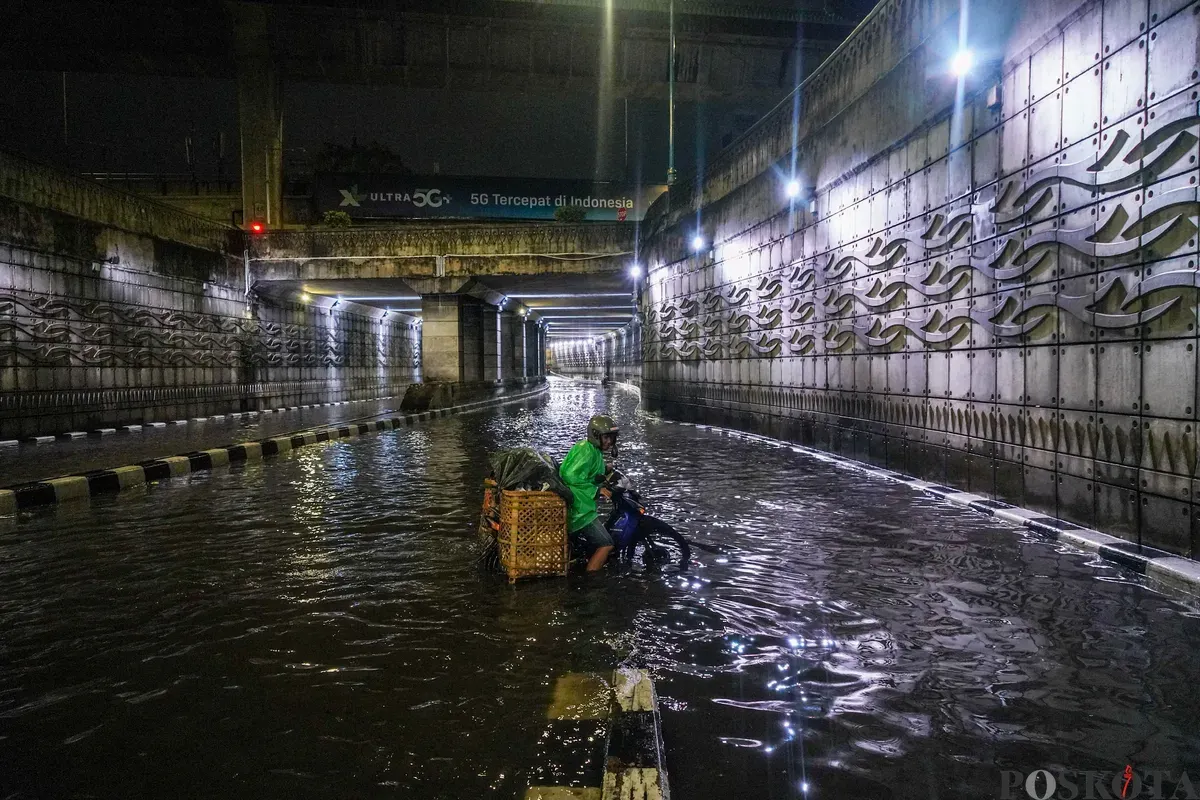 Pengendara melintasi genangan air banjir yang merendam Underpass Mampang, Jakarta Selatan, Minggu, 8 Maret 2026, dini hari. (Sumber: Poskota/Bilal Nugraha Ginanjar)