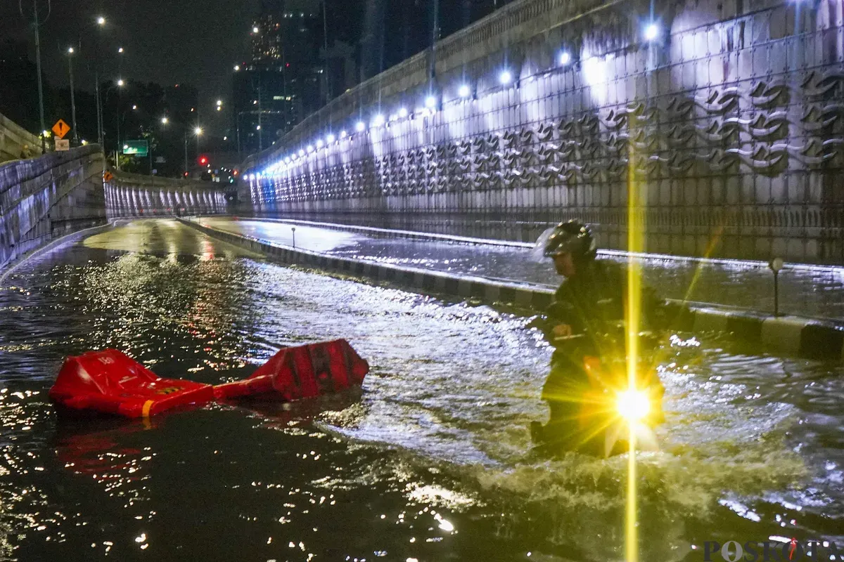 Pengendara melintasi genangan air banjir yang merendam Underpass Mampang, Jakarta Selatan, Minggu, 8 Maret 2026, dini hari. (Sumber: Poskota/Bilal Nugraha Ginanjar)