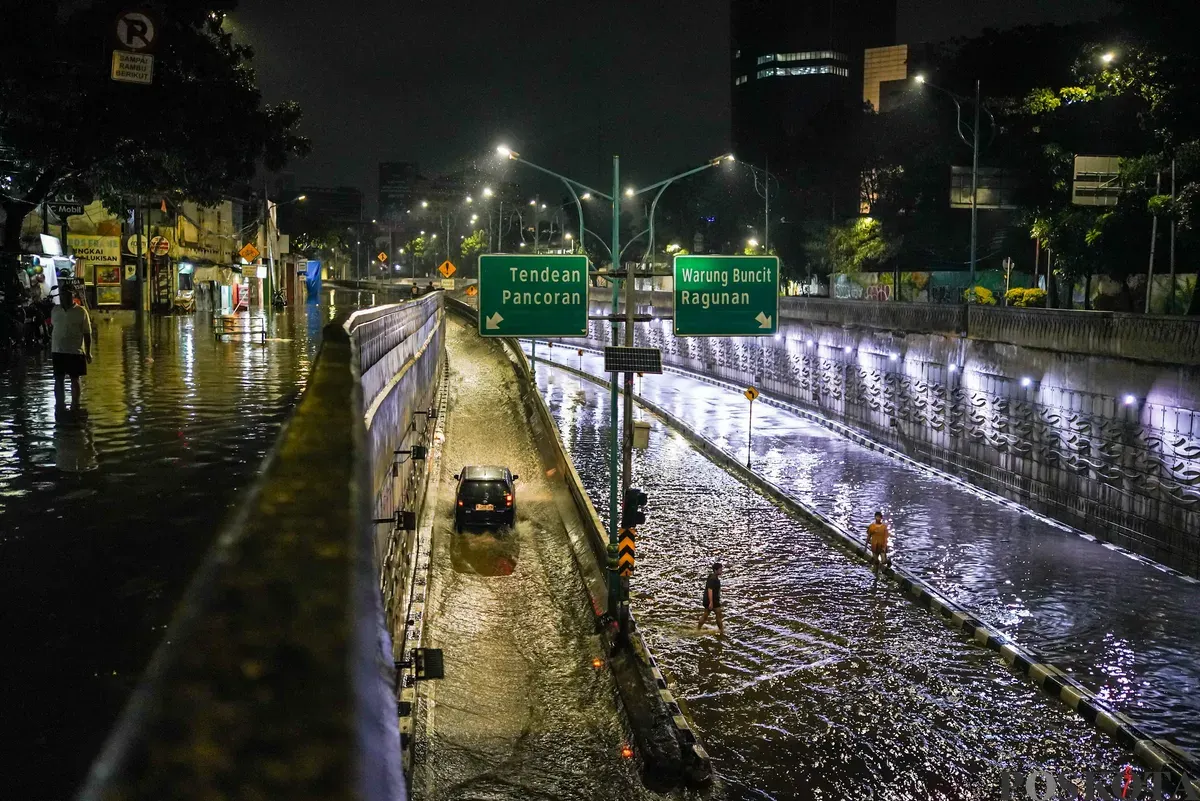 Pengendara melintasi genangan air banjir yang merendam Underpass Mampang, Jakarta Selatan, Minggu, 8 Maret 2026, dini hari. (Sumber: Poskota/Bilal Nugraha Ginanjar)