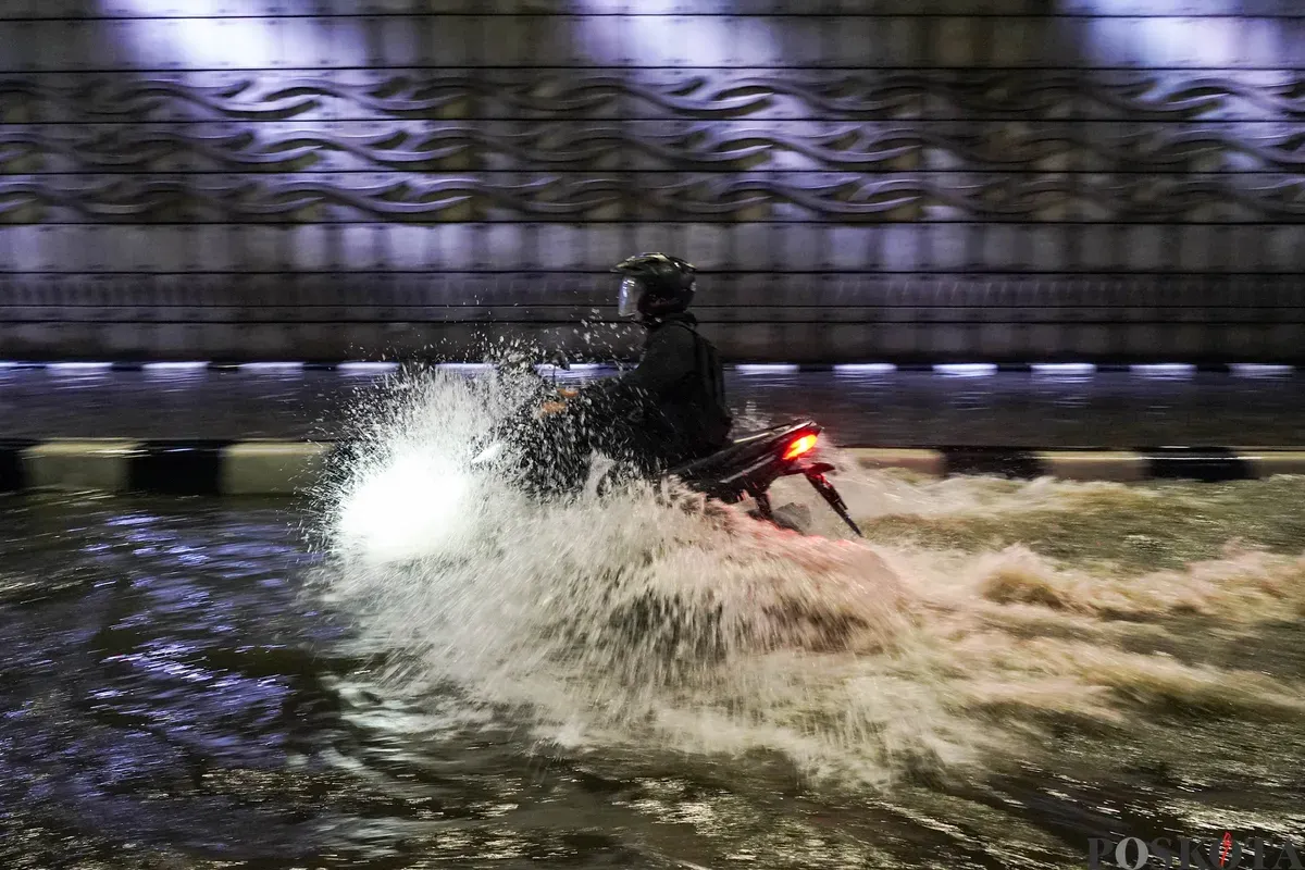 Pengendara melintasi genangan air banjir yang merendam Underpass Mampang, Jakarta Selatan, Minggu, 8 Maret 2026, dini hari. (Sumber: Poskota/Bilal Nugraha Ginanjar)
