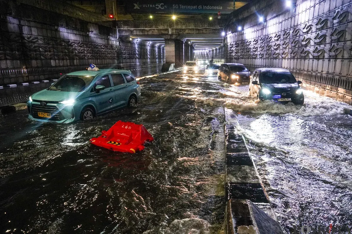 Pengendara melintasi genangan air banjir yang merendam Underpass Mampang, Jakarta Selatan, Minggu, 8 Maret 2026, dini hari. (Sumber: Poskota/Bilal Nugraha Ginanjar)