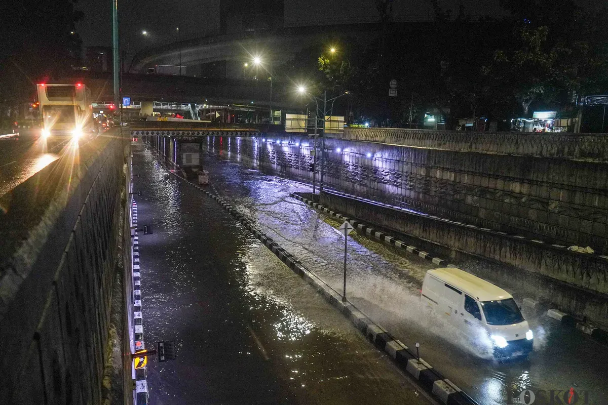 Pengendara melintasi genangan air banjir yang merendam Underpass Mampang, Jakarta Selatan, Minggu, 8 Maret 2026, dini hari. (Sumber: Poskota/Bilal Nugraha Ginanjar)