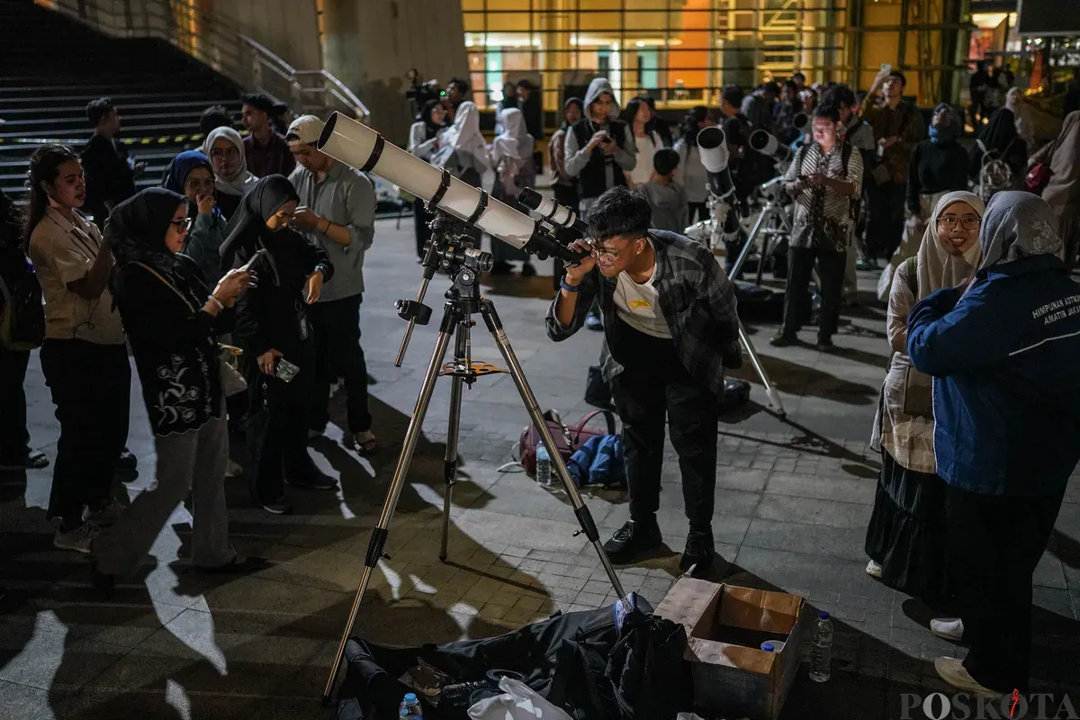 Pengunjung menggunakan teleskop untuk melihat gerhana bulan total di Taman Ismail Marzuki, Selasa, 3 Maret 2026. (Sumber: Poskota/Bilal Nugraha Ginanjar)
