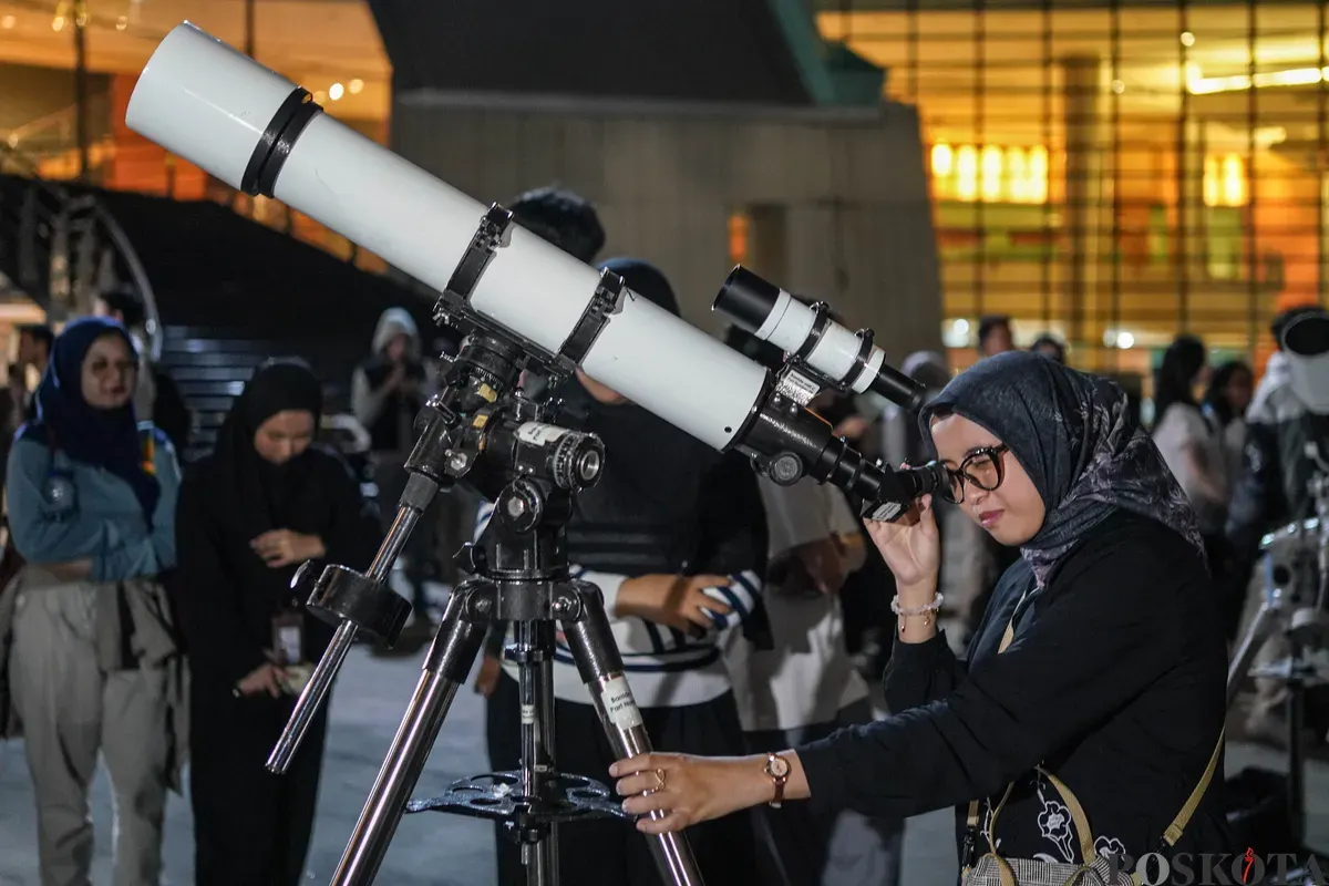 Pengunjung menggunakan teleskop untuk melihat gerhana bulan total di Taman Ismail Marzuki, Selasa, 3 Maret 2026. (Sumber: Poskota/Bilal Nugraha Ginanjar)
