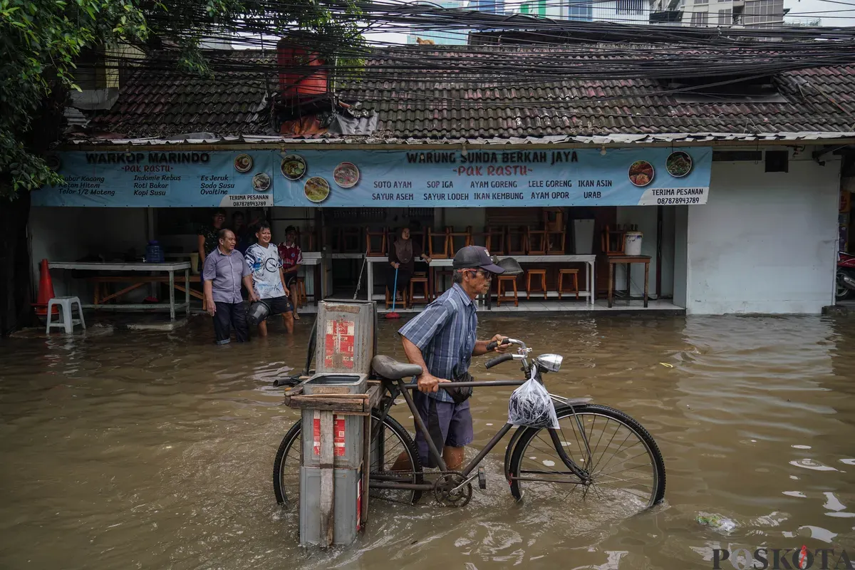 Warga melintasi genagan banjir di Jalan Bendungan Hilir, Jakarta Selatan, Minggu, 8 Maret 2026. (Sumber: Poskota/Bilal Nugraha Ginanjar)