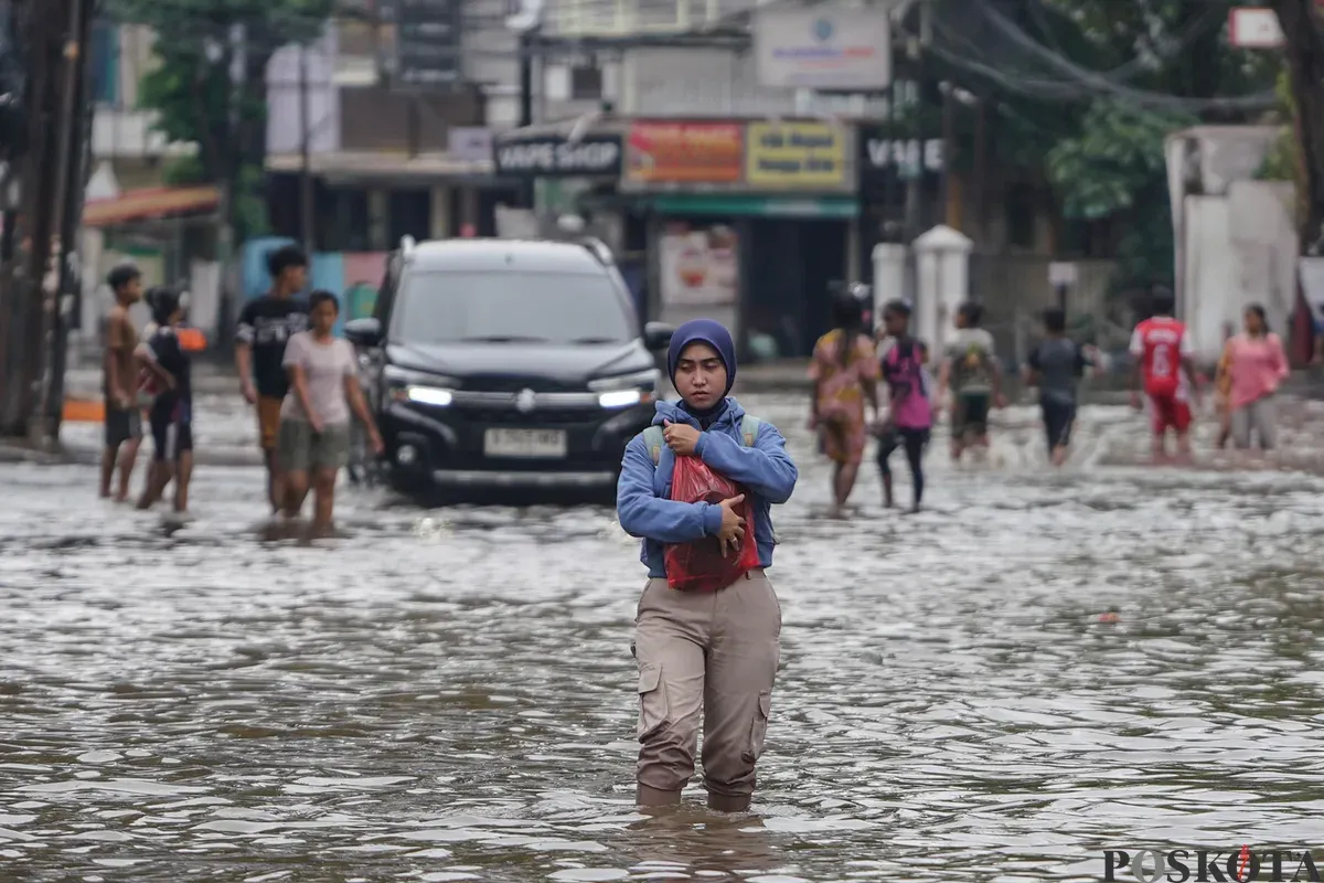 Warga melintasi genagan banjir di Jalan Bendungan Hilir, Jakarta Selatan, Minggu, 8 Maret 2026. (Sumber: Poskota/Bilal Nugraha Ginanjar)