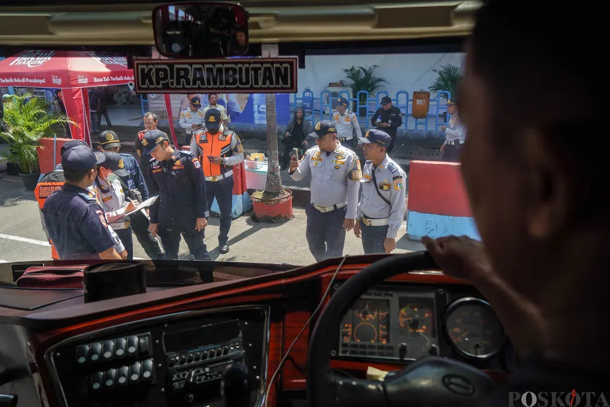 Petugas Dinas Perhubungan Provinsi DKI Jakarta mengecek kondisi tempat kemudi dari bus Antar Kota dan Antar Provinsi (AKAP) saat inspeksi kelaikan armada mudik Lebaran di Terminal Kampung Rambutan, Jakarta Timur, Selasa, 10 Maret 2026. (Sumber: Poskota/Bilal Nugraha Ginanjar)