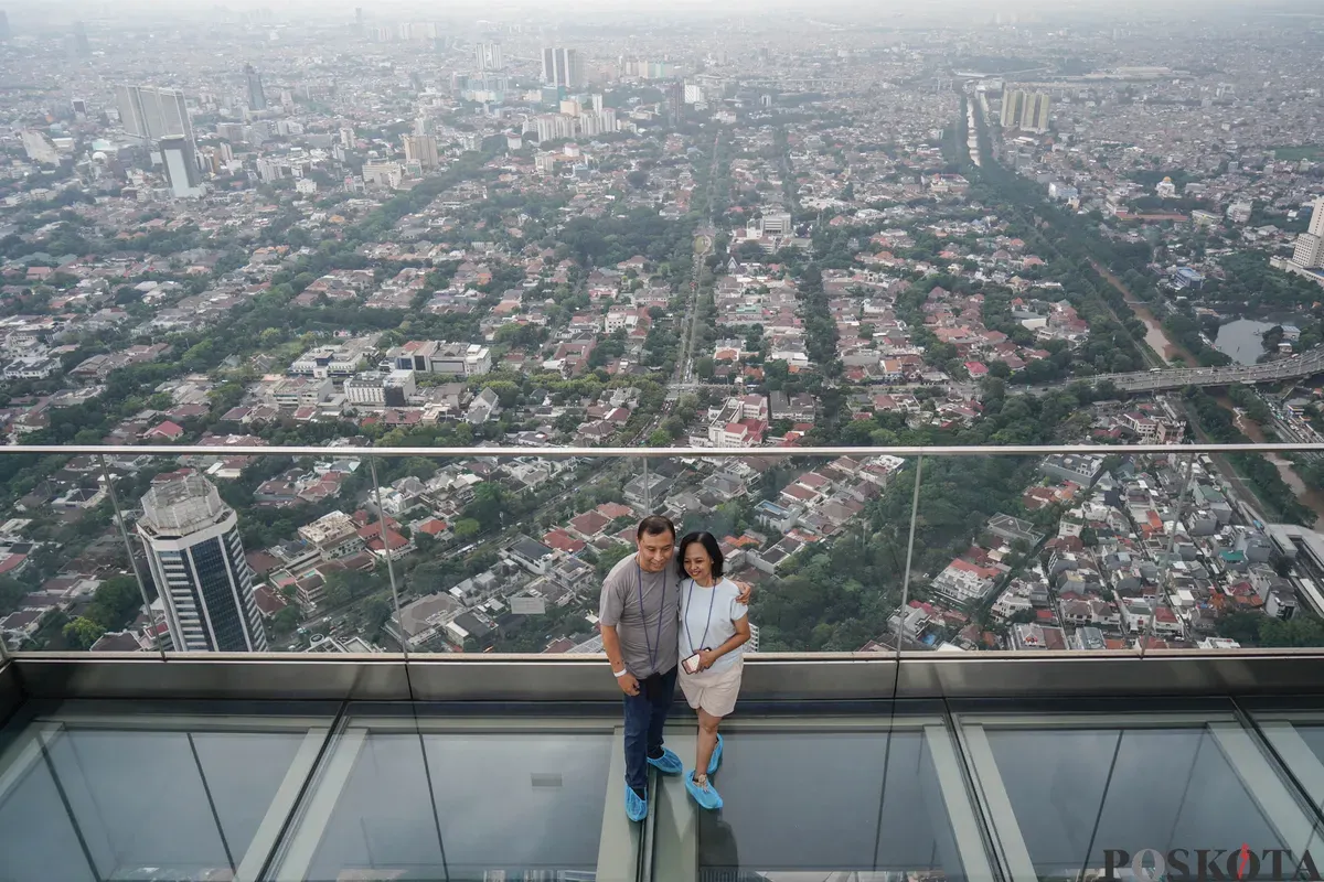 Warga berfoto diatap Gedung Thamrin Nine, Jakarta, Rabu, 11 Maret 2026. (Sumber: Poskota/Bilal Nugraha Ginanjar)