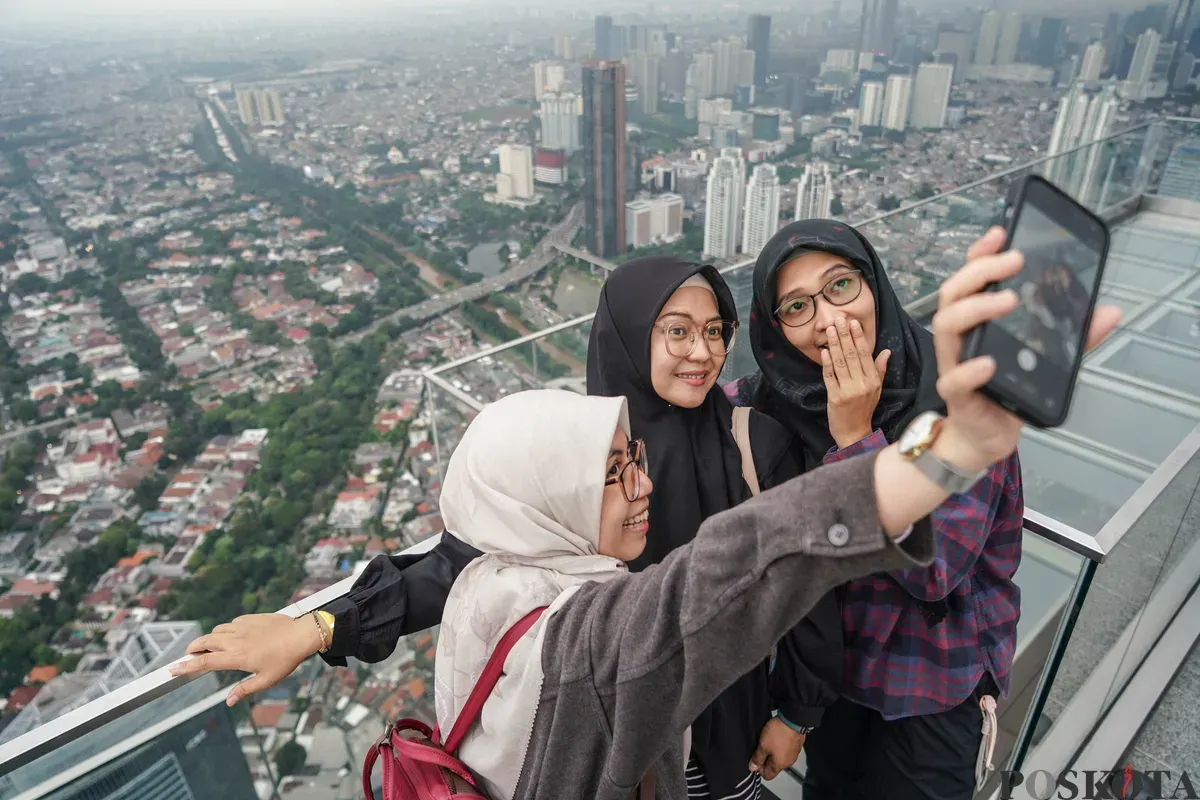 Warga berfoto diatap Gedung Thamrin Nine, Jakarta, Rabu, 11 Maret 2026. (Sumber: Poskota/Bilal Nugraha Ginanjar)