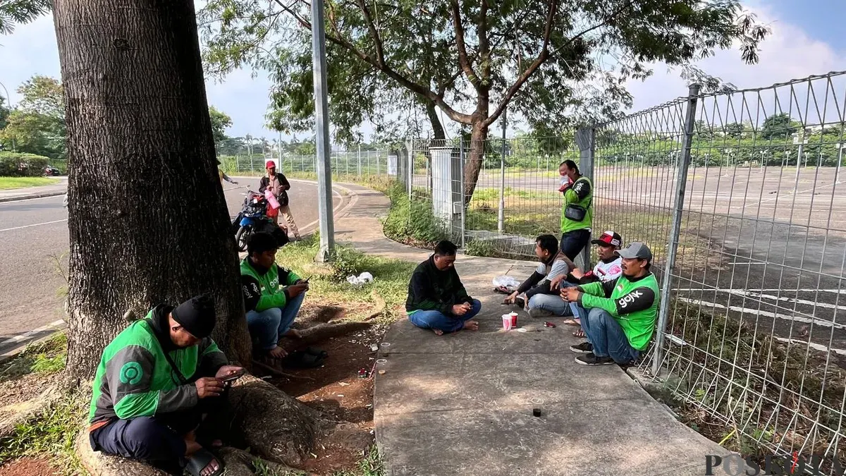 Chandra dan Riki bersama sejumlah driver lainnya saat istirahat sejenak di pinggir jalan Jakarta Garden City (JGC), Jakarta Timur, Sabtu, 2 Mei 2026. (Sumber: Poskota/M Tegar Jihad)