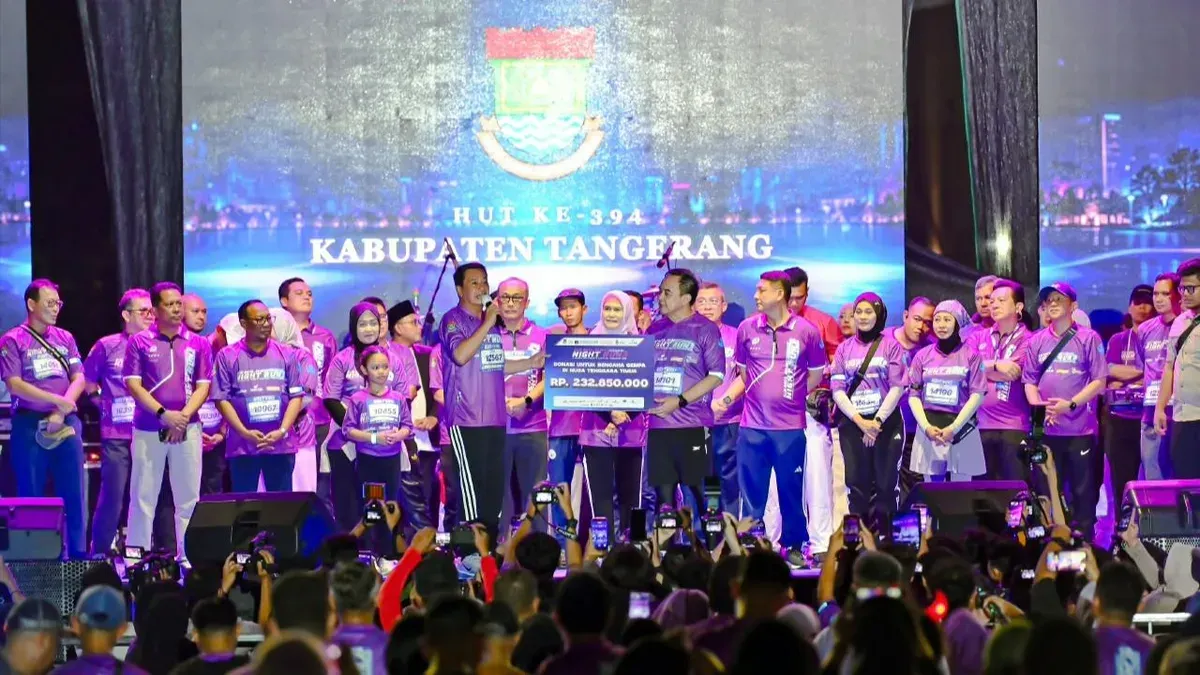 Ketua Korpri Kabupaten Tangerang, Soma Atmaja menyerahkan donasi kepada Bupati Tangerang Moch. Maesyal Rasyid saat ajang lari malam di kawasan Gading Serpong, Kecamatan Kelapa Dua, Banten, Sabtu, 10 Oktober 2026. (Sumber: Dok. Istimewa)