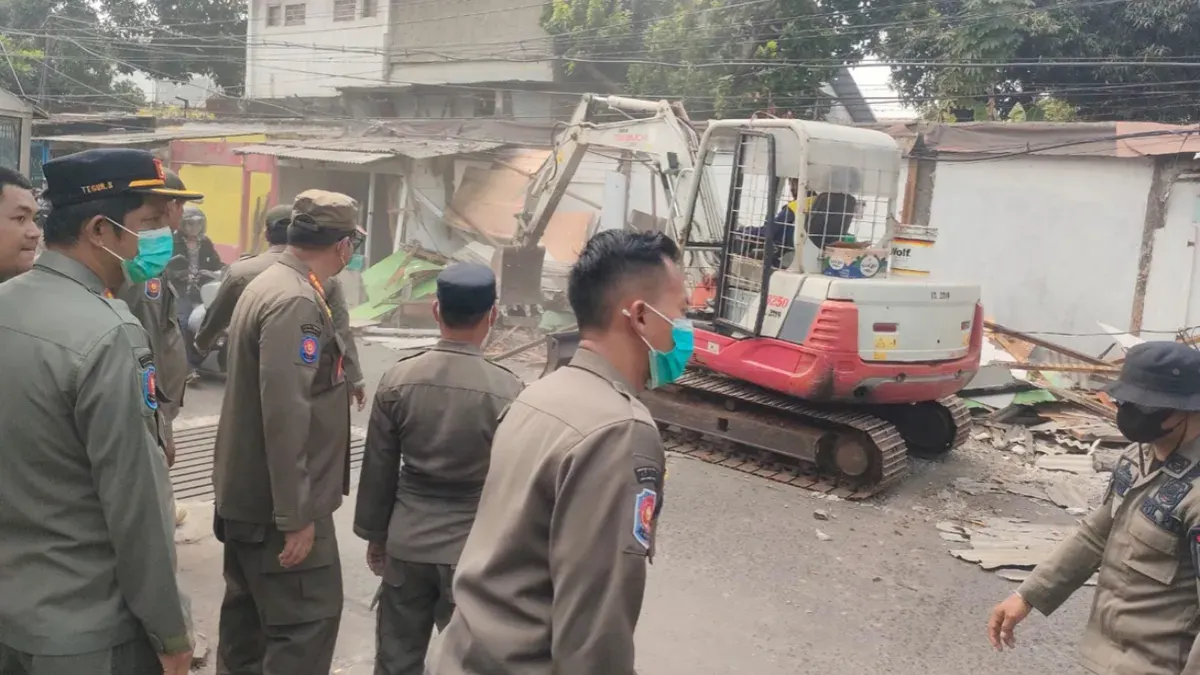 Satpol PP Kota Depok menggunakan alat berat eksavator membongkar bangunan liar dan PKL di Cimanggis, Kota Depok. (Sumber: Satpol PP Depok)