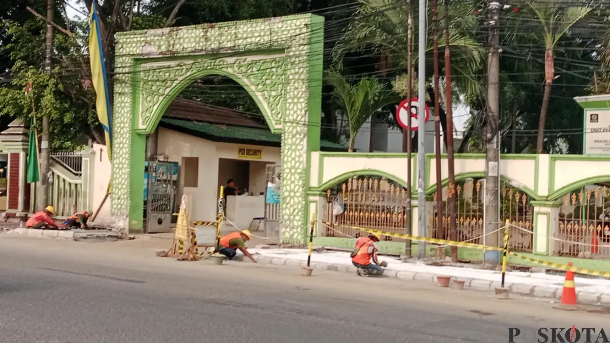 Sejumlah pekerja menyelesaikan pembangunan dan perbaikan trotoar di depan kawasan Masjid Al-Ittihad, Jumat, 16 Oktober 2026. (Sumber: Poskota/ Rizki Gojali)
