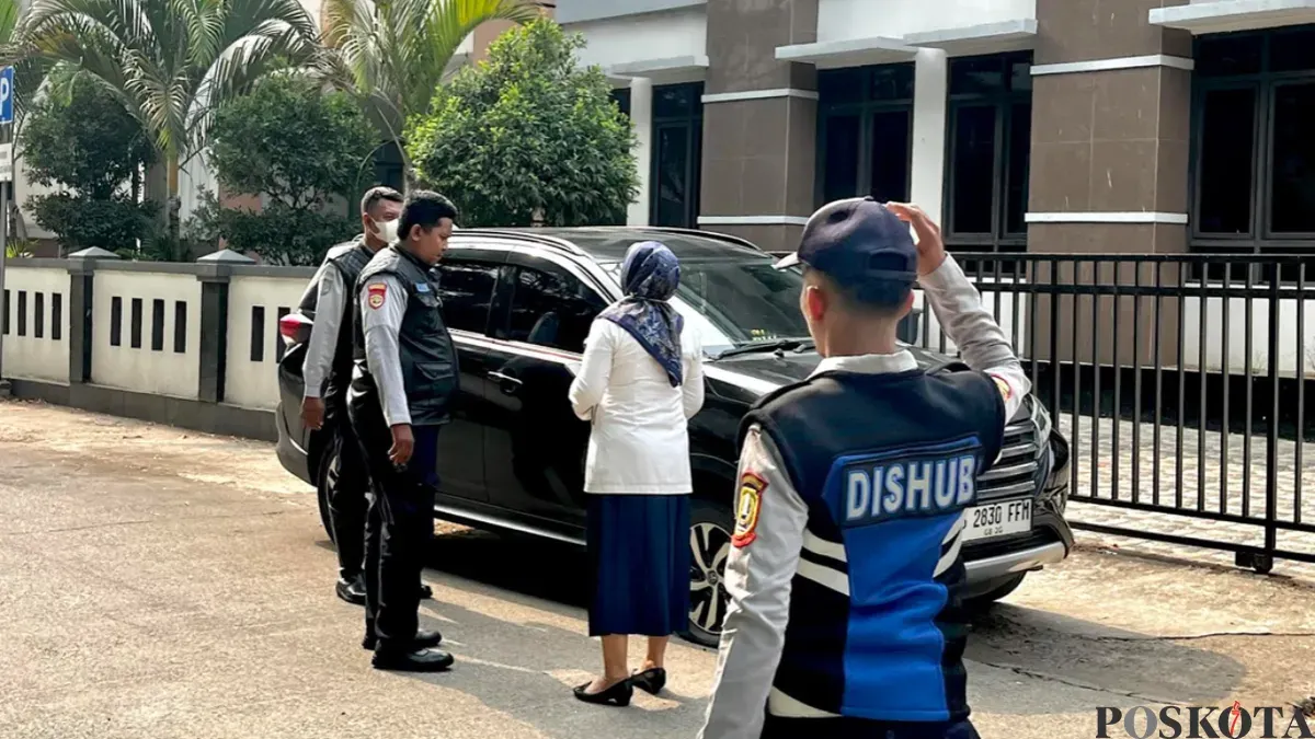 Petugas Dinas Perhubungan Kota Bekasi menegur pegawai Pemkot Bekasi yang masih memarkirkan kendaraannya di pinggir jalan saat penataan parkir mulai diberlakukan, Senin, 19 Oktober 2026. (Sumber: Poskota/Dini Aghnny Khoiriyah)