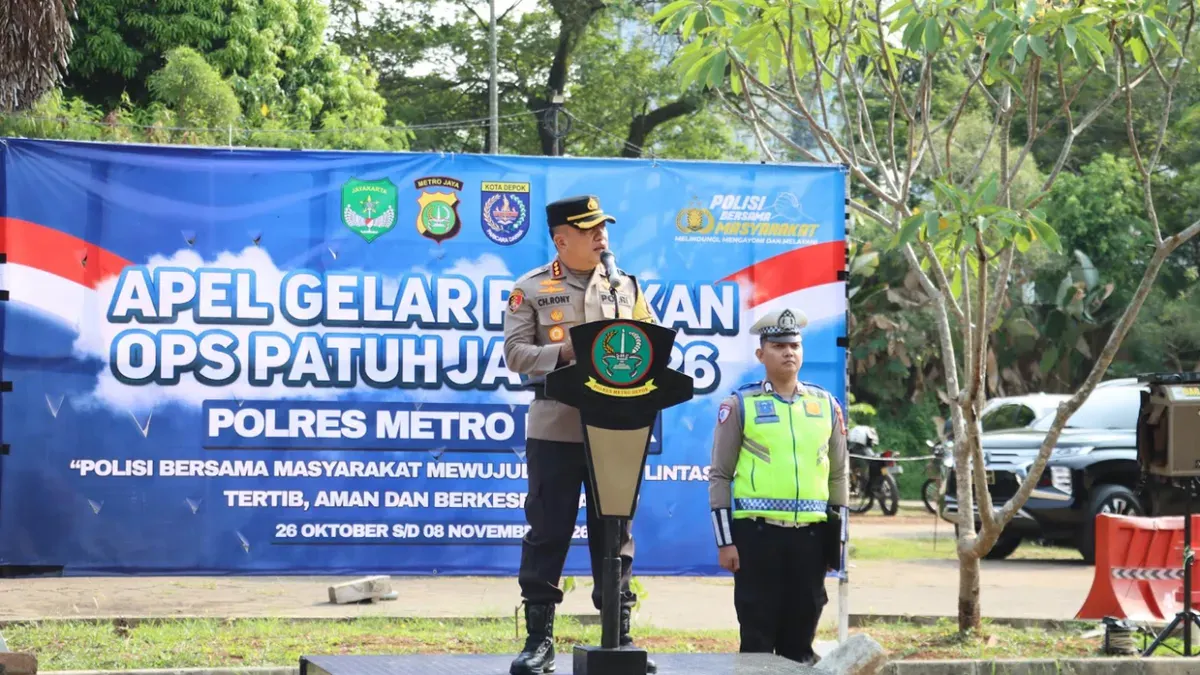 Kapolres Metro Depok, Kombes Pol Christian Rony Putra menyematkan pita Operasi Patuh Jaya 2026 ke perwakilan anggota gabungan di saat Apel Gelas Pasukan Operasi Patuh Jaya 2026 di Mapolres Metro Depok. (Sumber: Polres Depok)
