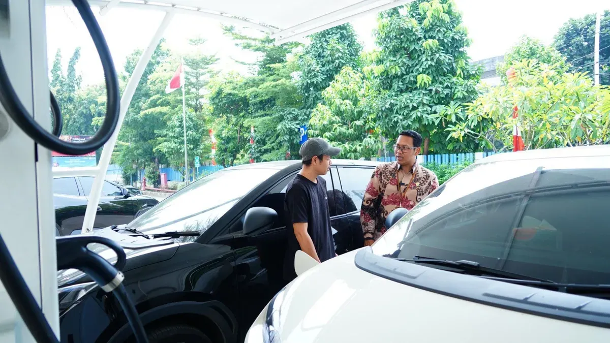 Senior Manager Niaga dan Manajemen Pelanggan PLN UID Jakarta Raya, Wira Bhakti Dharma berbincang dengan pengguna mobil listrik yang tengah mengisi daya kendaraannya di SPKLU Kantor PLN UP3 Cempaka Putih. (Sumber: Dok. PLN UID Jakarta Raya)