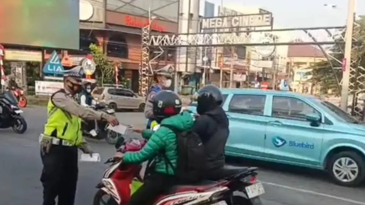 Petugas Lantas Polsek Cinere membagikan masker ke pengguna jalan di Jalan Raya Cinere. (Sumber: Satlantas Polsek Cinere)