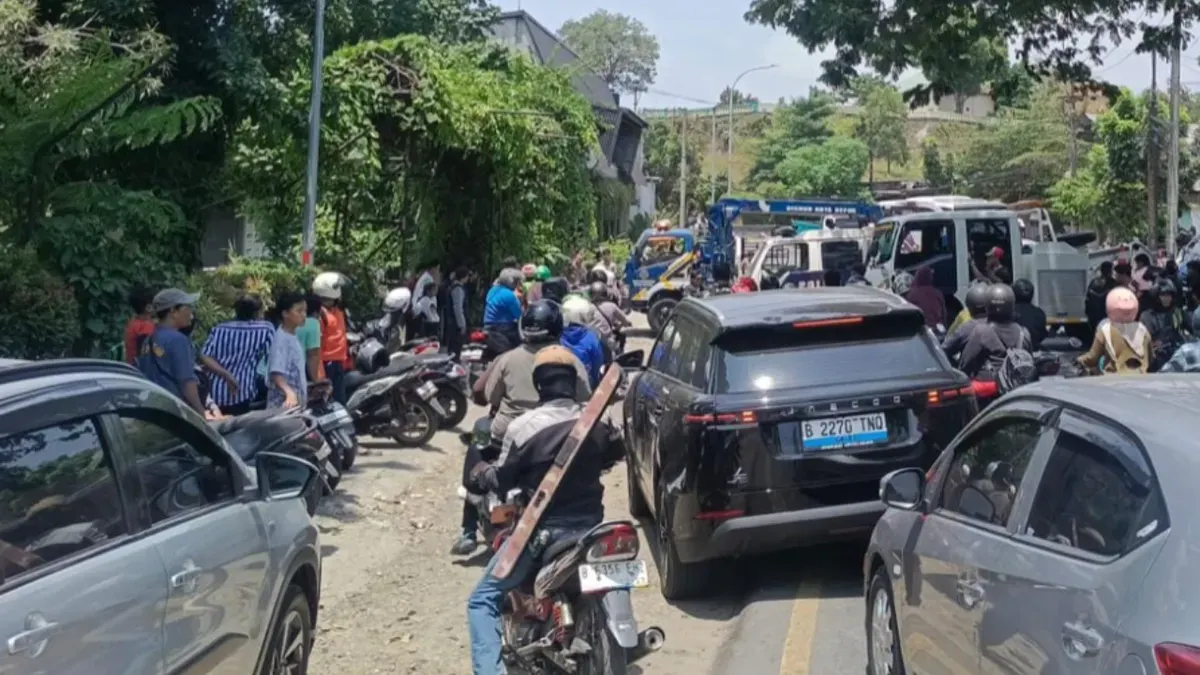 Situasi lalu lintas di Jalan Raya KSU (Pondok Gurame) padat merayap setelah mobil elf dari dalam Kali Cikumpa berhasil di evakuasi. (Sumber: Satlantas Polsek Sukmajaya)